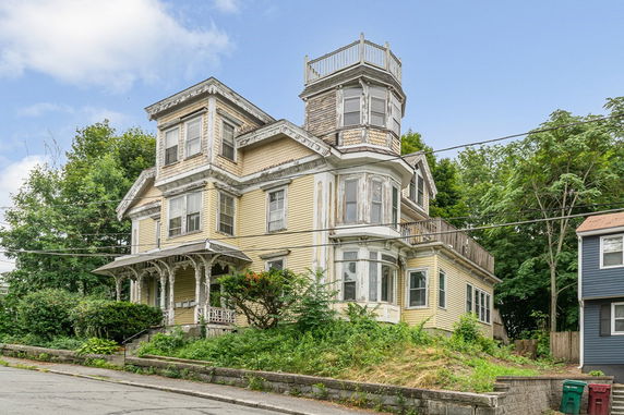 Front view of a multi-story house with a unique architectural design and a small porch.