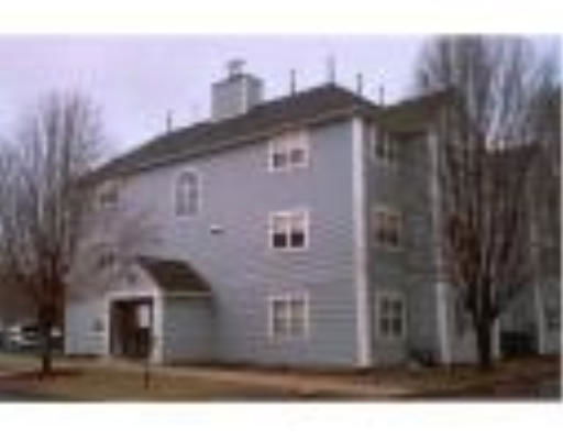 Front view of a three-story building with multiple windows and a chimney.