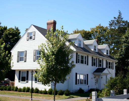 Front view of a multi-story house with a chimney.
