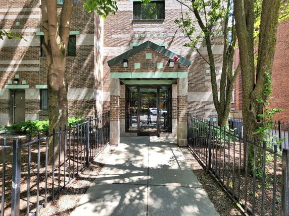 Front view of a building entrance with glass doors and brick exterior.