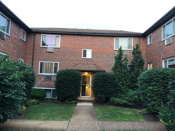 Front view of a two-story brick apartment building.