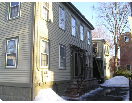 Front view of a multi-story house with several windows and a side entrance.