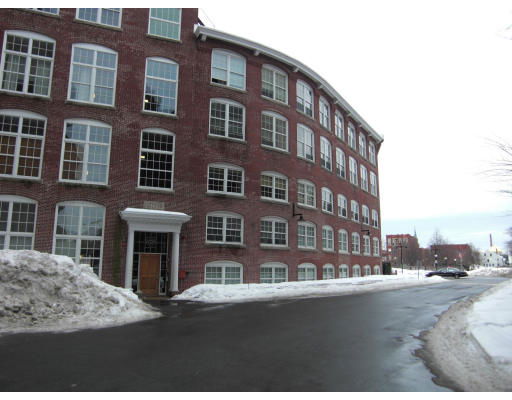 Front view of a multi-story brick building with large windows and a main entrance.