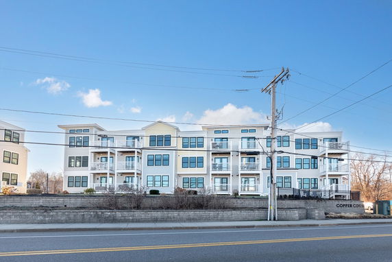 Front view of a multi-story residential building with balconies.