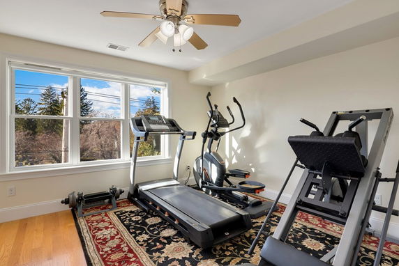 Room equipped with exercise machines including a treadmill and elliptical.