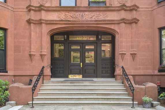 Front view of a vintage-style building entrance with ornate detailing and steps leading to the door.