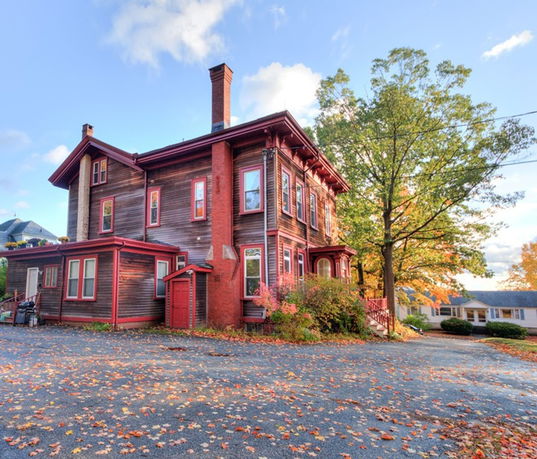 Front view of a two-story house with red and brown exterior.