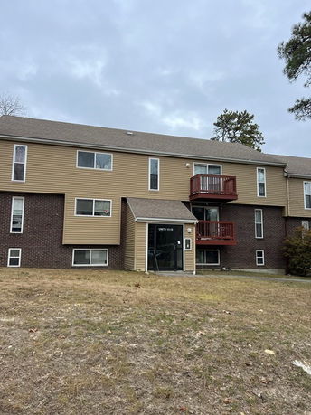 Front view of a three-story apartment building with balconies.