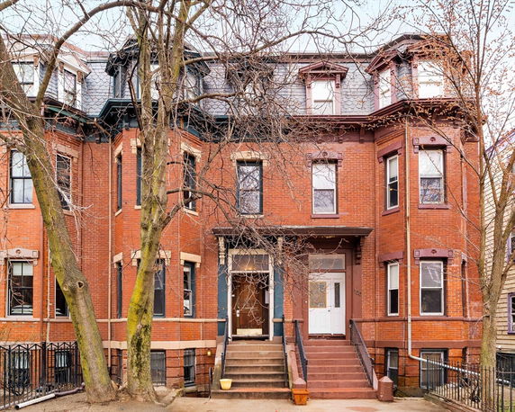 Front view of a multi-story brick building with multiple windows and a central entrance.