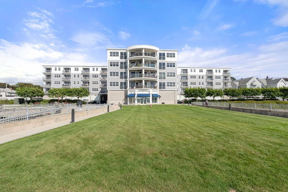Front view of a multi-story residential building with balconies and large windows.