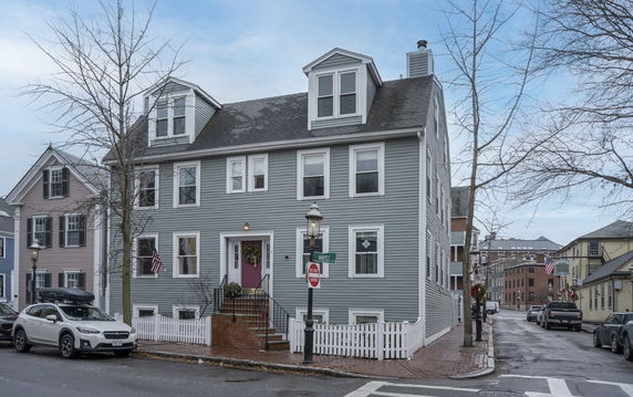Front view of a three-story house with dormer windows.