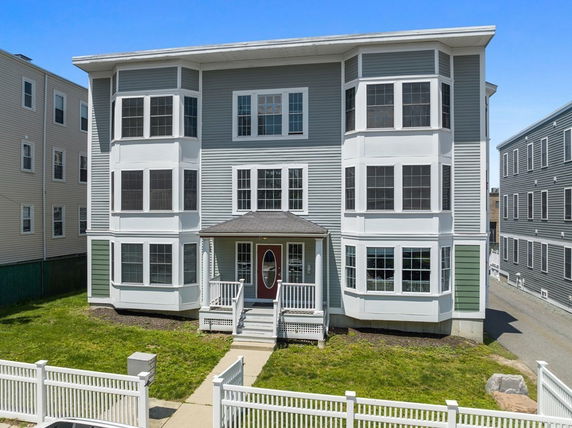 Front view of a multi-story residential building with bay windows.