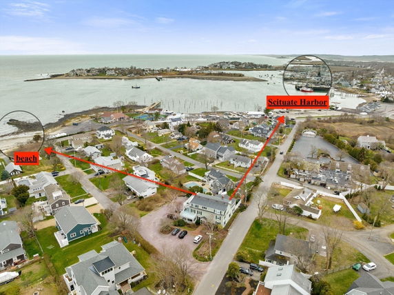 Panoramic view of a coastal residential area near a harbor and beach.