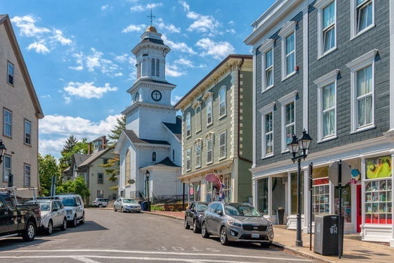 Street view showing multiple buildings including one with a prominent tower.