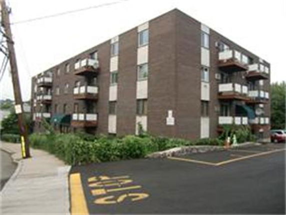 Front view of a multi-story apartment building with balconies.