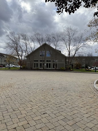 Front view of a large house with tall windows and a steep roof.