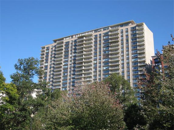 Front view of a tall residential building with multiple balconies.