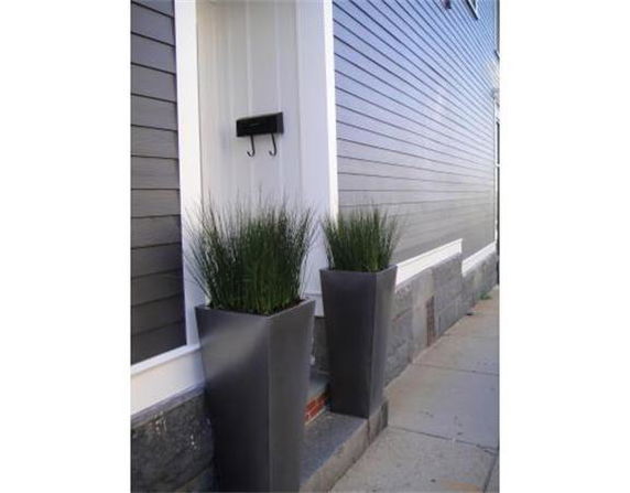 Side view of a house entrance with tall planters
