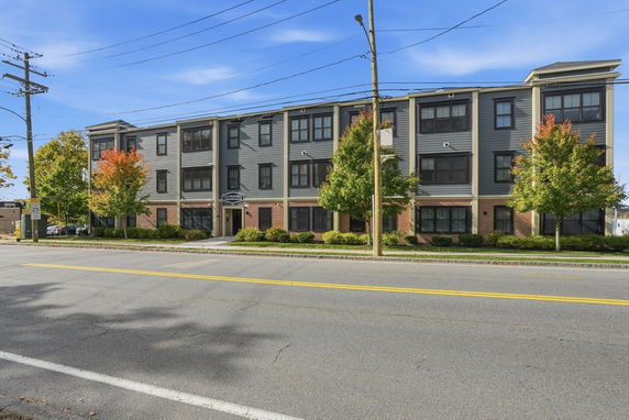 Front view of a three-story residential building with multiple units.