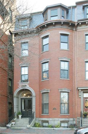 Front view of a multi-story brick building with arched entrance.