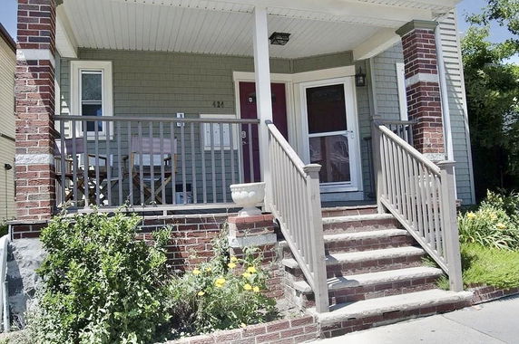 Front view of a house with a porch and brick exterior.