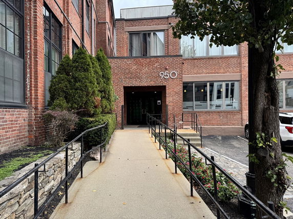 Front view of a brick building with a ramp leading to the entrance.