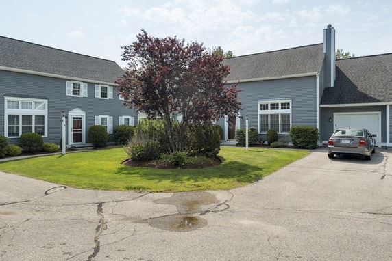 Front view of a two-story house with a car parked in the driveway.