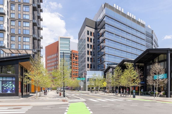 Front view of multiple modern high-rise buildings with glass facades in an urban environment.