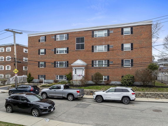 Front view of a multi-story brick apartment building.