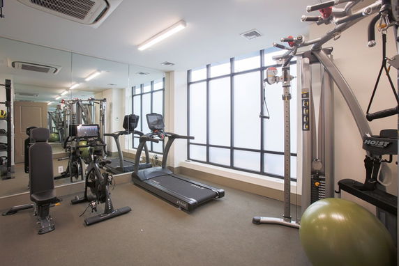 Indoor gym area with exercise equipment including a treadmill and cycle.