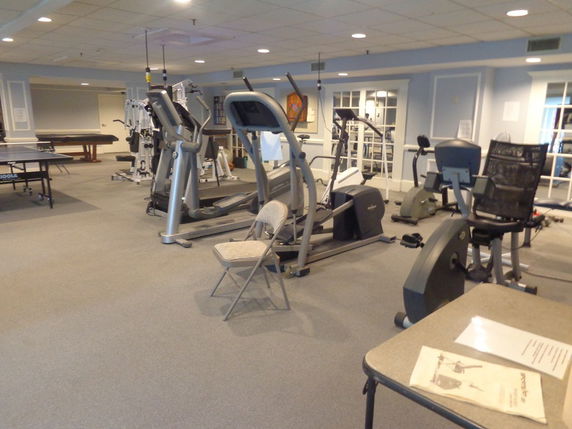 Indoor area with gym equipment and a table tennis setup.