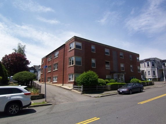 Front view of a three-story brick apartment building.