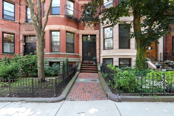 Front view of a multi-story brick townhouse with a central entrance.