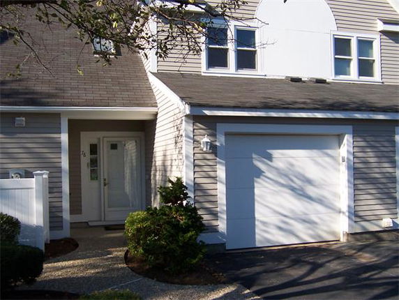 Front view of a house with a garage and an entrance path.