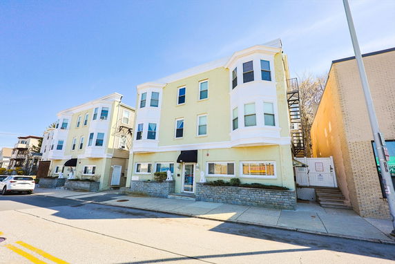 Front view of a multi-story residential building with bay windows.