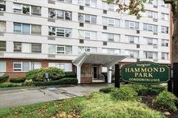 Front view of a multi-story condominium building with an entrance canopy.