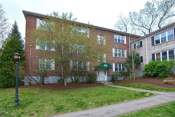 Front view of a multi-story brick building with multiple windows and a central entrance.