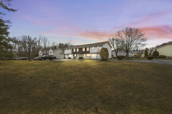 Front view of a two-story house with a driveway and a front lawn.