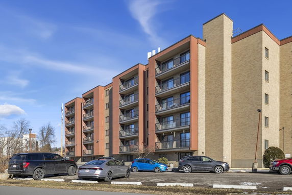 Front view of a multi-story apartment building with balconies.