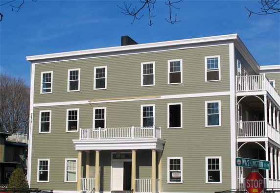 Front view of a multi-story building with multiple windows and balconies.