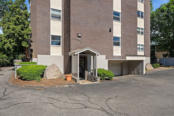 Front view of a multi-story brick building with a small entrance canopy.