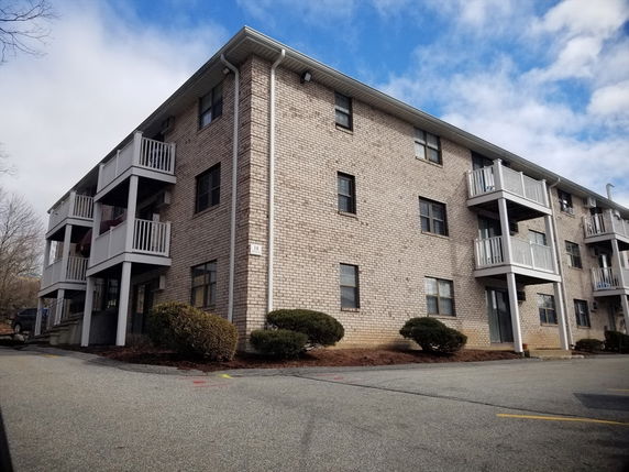 Front view of a multi-story brick building with balconies.