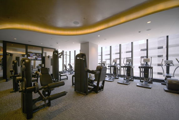 Indoor gym area with exercise equipment and large windows.