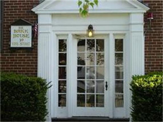Front view of a brick building entrance with glass doors and a canopy.