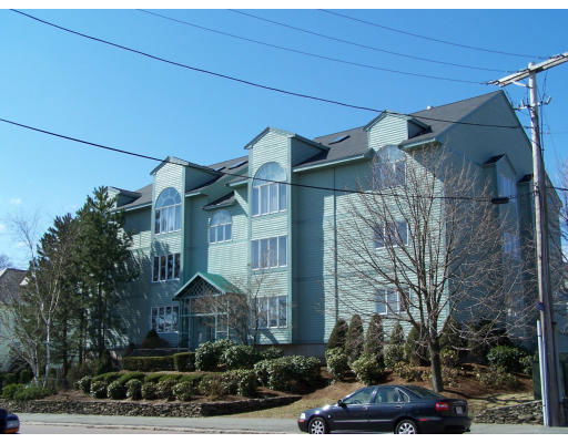Front view of a multi-story building with multiple windows and a sloped roof.