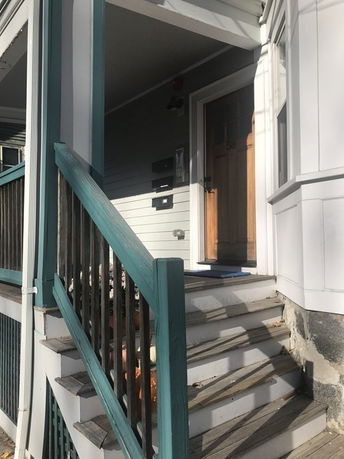 Front view of a house with steps leading to the entrance.