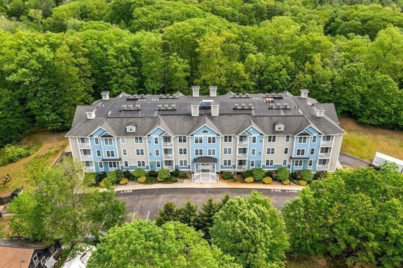 Elevated view of a three-story residential building with blue and gray exterior.