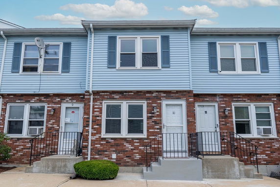 Front view of a two-story townhouse with brick and siding exterior.