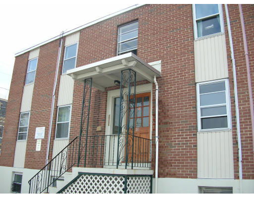 Front view of a two-story brick building with a central entrance and metal railings.