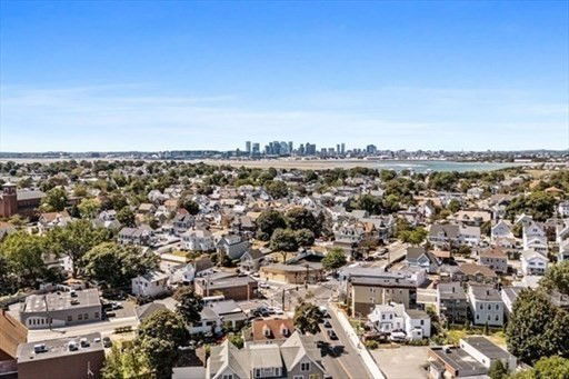 Panoramic view of a suburban neighborhood with a city skyline in the distance.